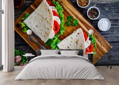 Italian piada wraps - piadina stuffed with fresh lettuce  mozzarella and sliced tomatoes on wooden table Wall mural