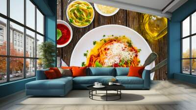 Linguine with tomato sauce, parmesan cheese and basil leaves served on wooden table  Wall mural