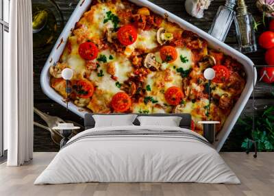 Noodle casserole with minced meat, mozzarella cheese and vegetables on wooden table
 Wall mural