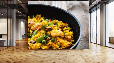 Paella seafood in cooking pan on wooden background Wall mural