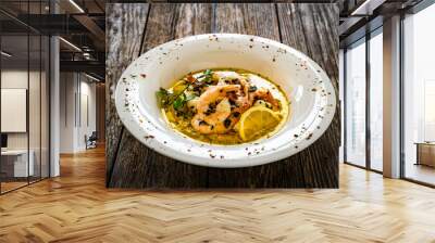 Roast prawns in butter sauce with lemon, garlic and parsley on wooden table
 Wall mural