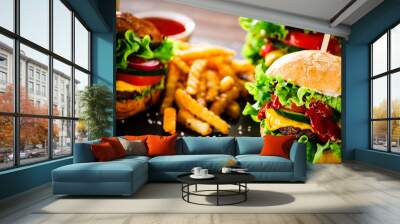 Tasty cheeseburgers with french fries served on black stone Wall mural