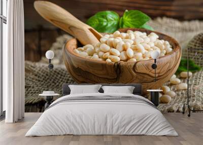 White beans in a wooden bowl on a burlap background with a rustic wood spoon. Wall mural