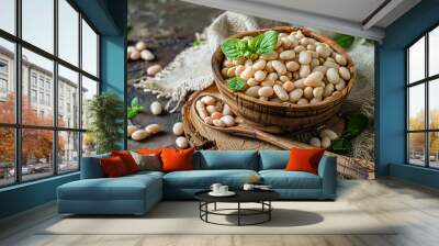 White beans in a wooden bowl with a spoon on a table. Wall mural