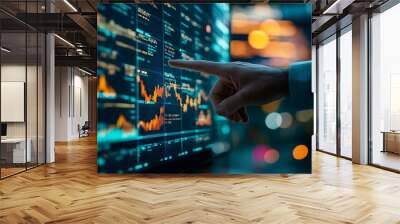 A man’s hand reaches out to touch a large monitor displaying forex diagrams and stock market charts, with financial data and trends illuminated on the screen Wall mural