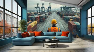 A worker wearing an orange vest and yellow helmet stands in front of many stacked containers at the port, overlooking the scene from above with high resolution. The container yard is filled with vario Wall mural