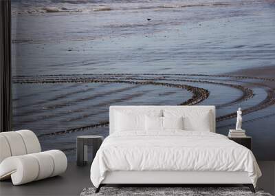 Tire tracks in the wet sand of the water edge of an ocean beach Wall mural