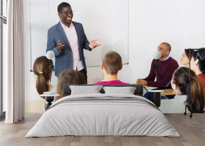 African american male teacher lecturing to adult students at auditorium Wall mural