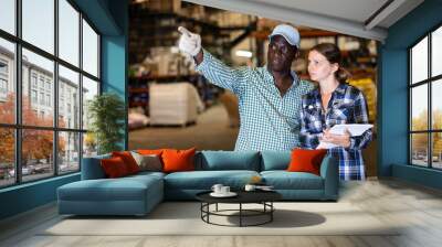 African American man and woman choosing building materials, man pointing to something in hardware store Wall mural