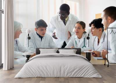 African-american man professor explaining subject to group of medical students and colleagues in university. Wall mural