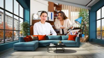 Angry business woman criticizing sad frustrated female employee sitting at office desk at work Wall mural