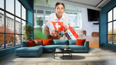 Assistant girl prepares office for international negotiations and meetings of leaders. Lady sets miniatures flags of Iraq and Switzerland on table. Close-up Wall mural