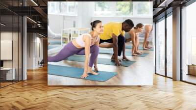 Body arching exercises during a Pilates workout for multinational group athletes Wall mural