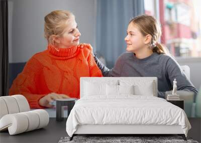 Cheerful teenage schoolgirl taking money euro from her positive mother in home interior Wall mural