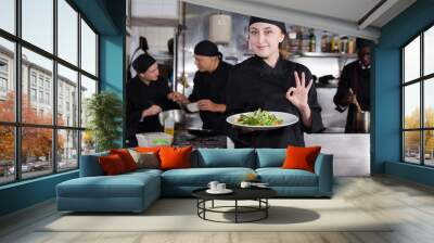 Confident female chef with a team of cooks in restaurant kitchen Wall mural