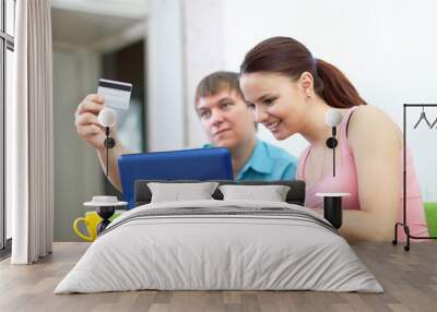 couple buying online with laptop Wall mural