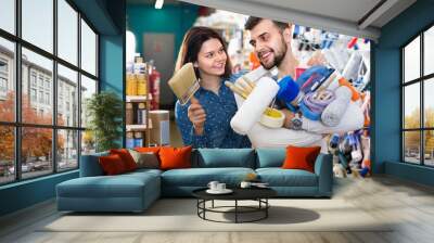 Couple purchasing tools for house improvements in paint supplies store Wall mural