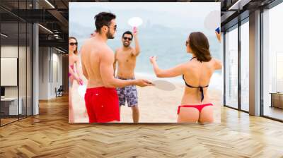 Couples playing games on a beach Wall mural