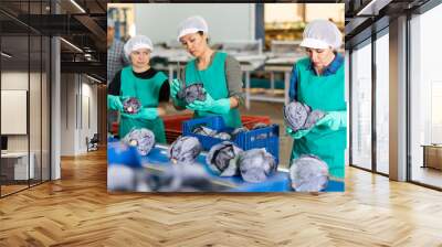 diligent positive women sorting red cabbage to crates and checking quality at on vegetable factory Wall mural