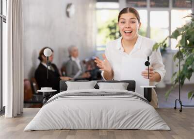 Excited young female office worker rejoices at her success Wall mural