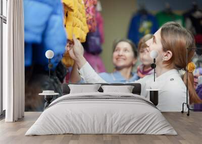 family chooses winter wear at clothes store Wall mural