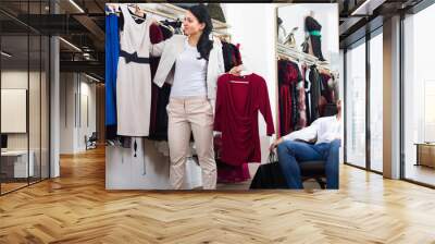 Family choosing dress and blouse at clothing shop Wall mural