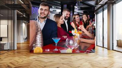 Friendly colleagues partying in bar and toasting drinks Wall mural