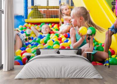 girl playing with multicolored plastic balls . Wall mural