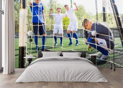 Goalkeeper missed the ball into the goal. Young teen soccer game Wall mural