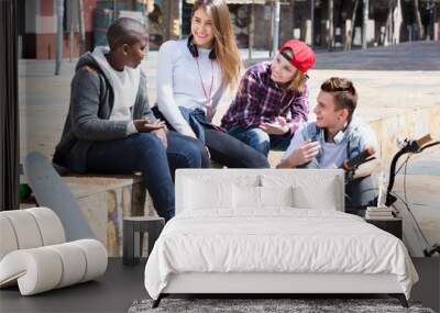 Group of teenage friends relaxing and chatting Wall mural