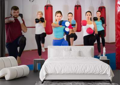 group of women and their trainer are boxing in gym Wall mural