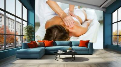 Hands of old masseur conducting back massage for woman client in procedure room Wall mural