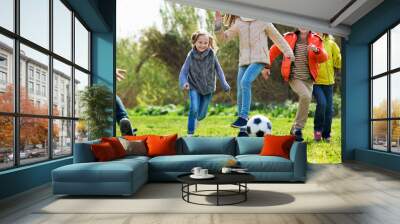 Happy kids playing football outdoors Wall mural