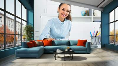 Happy woman working with paperwork and laptop Wall mural