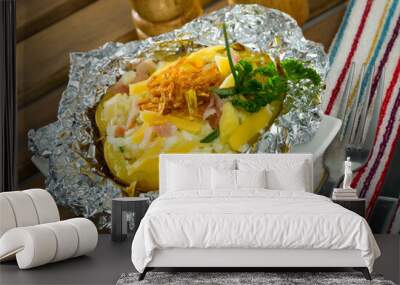 Image of tasty cooked baked in foil potatoes with bacon, cheese and fried onion Wall mural