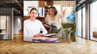 Irritated woman boss scolding stressed manager for incompetence with documents in office Wall mural