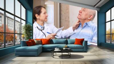 mature doctor touching  neck of   man Wall mural