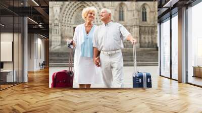 Mature travelers strolling with luggage Wall mural