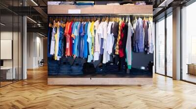 Men casual clothes on hangers and shelves in apparel store Wall mural