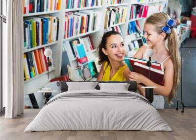 Mother with daughter in bookstore Wall mural