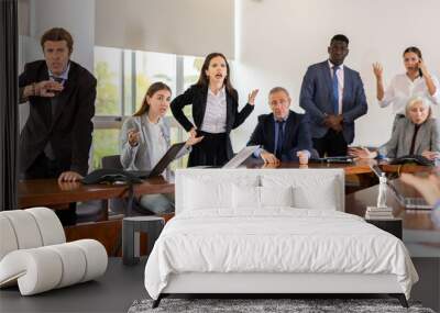 Multiracial group of age-diverse business people in formalwear having an emotional dispute and verbal altercation during corporate group meeting in conference room at office finding no compromise in Wall mural