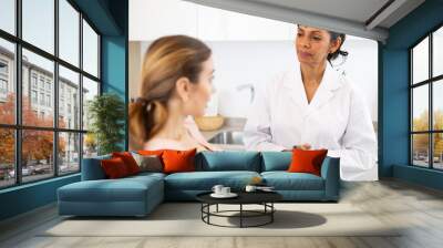 Plastic surgeon and english woman discussing procedure of breast augmentation during consultation at clinic Wall mural