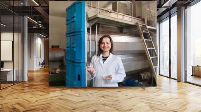 Portrait of diligent smiling female posing with olive oil contai Wall mural