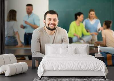 Portrait of positive adult student in the university auditorium during a break Wall mural