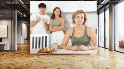 Portrait of thoughtful woman who had conflict with adult children while cooking dinner in home kitchen Wall mural