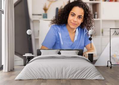 Portrait of young female doctor working on laptop at office in hospital Wall mural