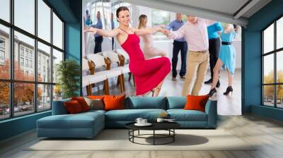 Positive adult pairs practicing vigorous jive movements in dance class Wall mural