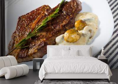 Prepared beef steak with mushrooms sauce branch of rosemary at white plate Wall mural