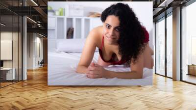 Provocative portrait of sexy girl in red underwear on the bed Wall mural