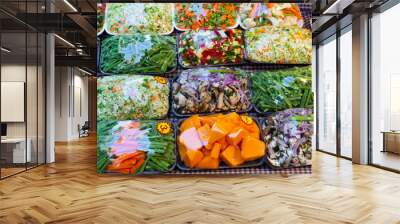 Sets of different chopped fresh vegetables wrapped in film at market Wall mural